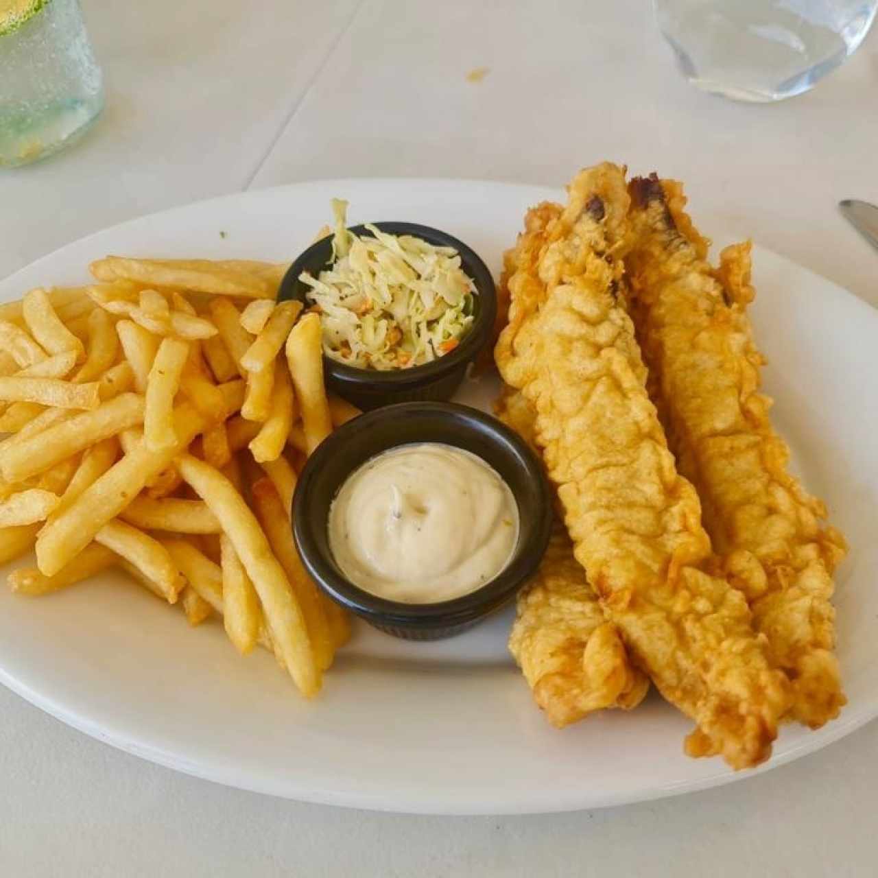 PESCADO Y PAPAS SIR FRANCIS (Tiras de Corvina Rebozadas en Tempura de Cerveza Panamá, servidas con una Deliciosa Mayonesa de Ajo, acompañadas de Papas Fritas y Ensalada de Repollo y Zanahoria)