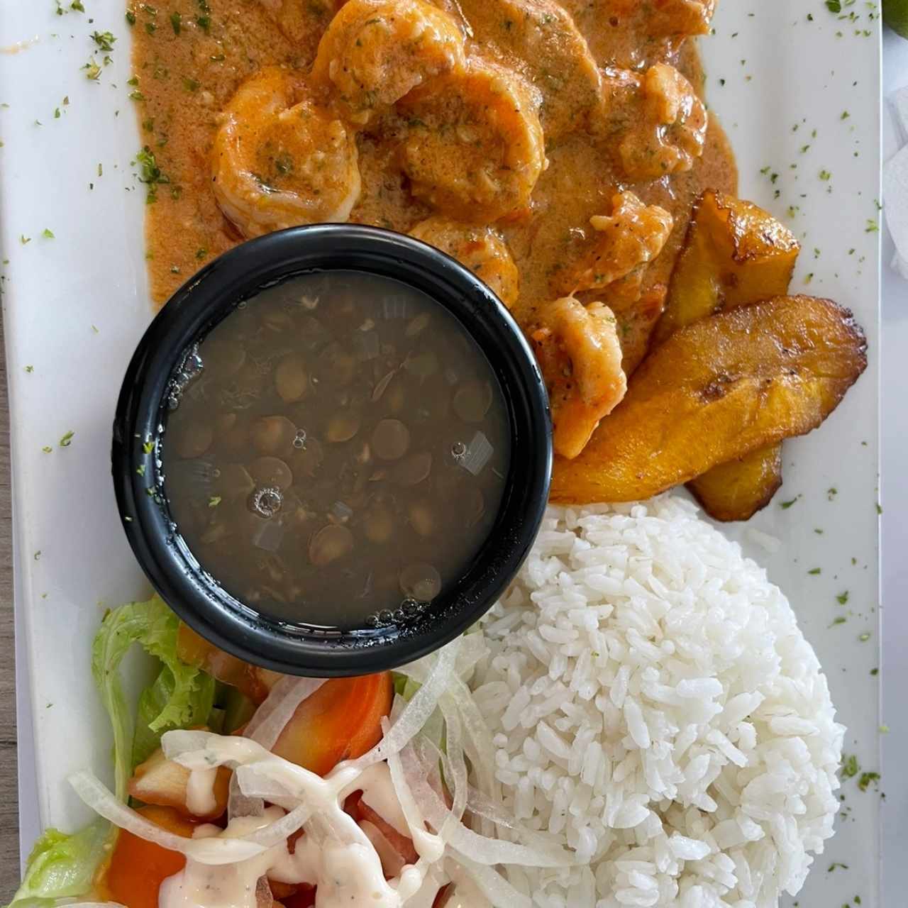 Camarones al ajillo con arroz, lentejas, ensalada y tajada