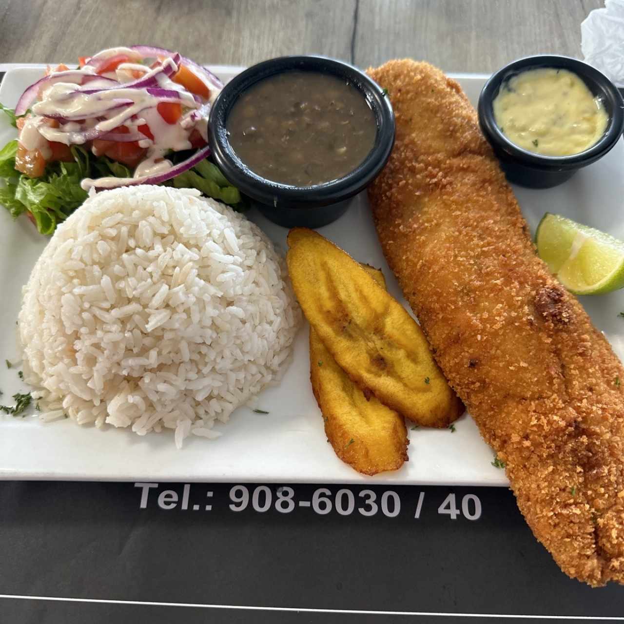 Filete de corvina apanado con arroz, ensalada, menestra y tajadas 