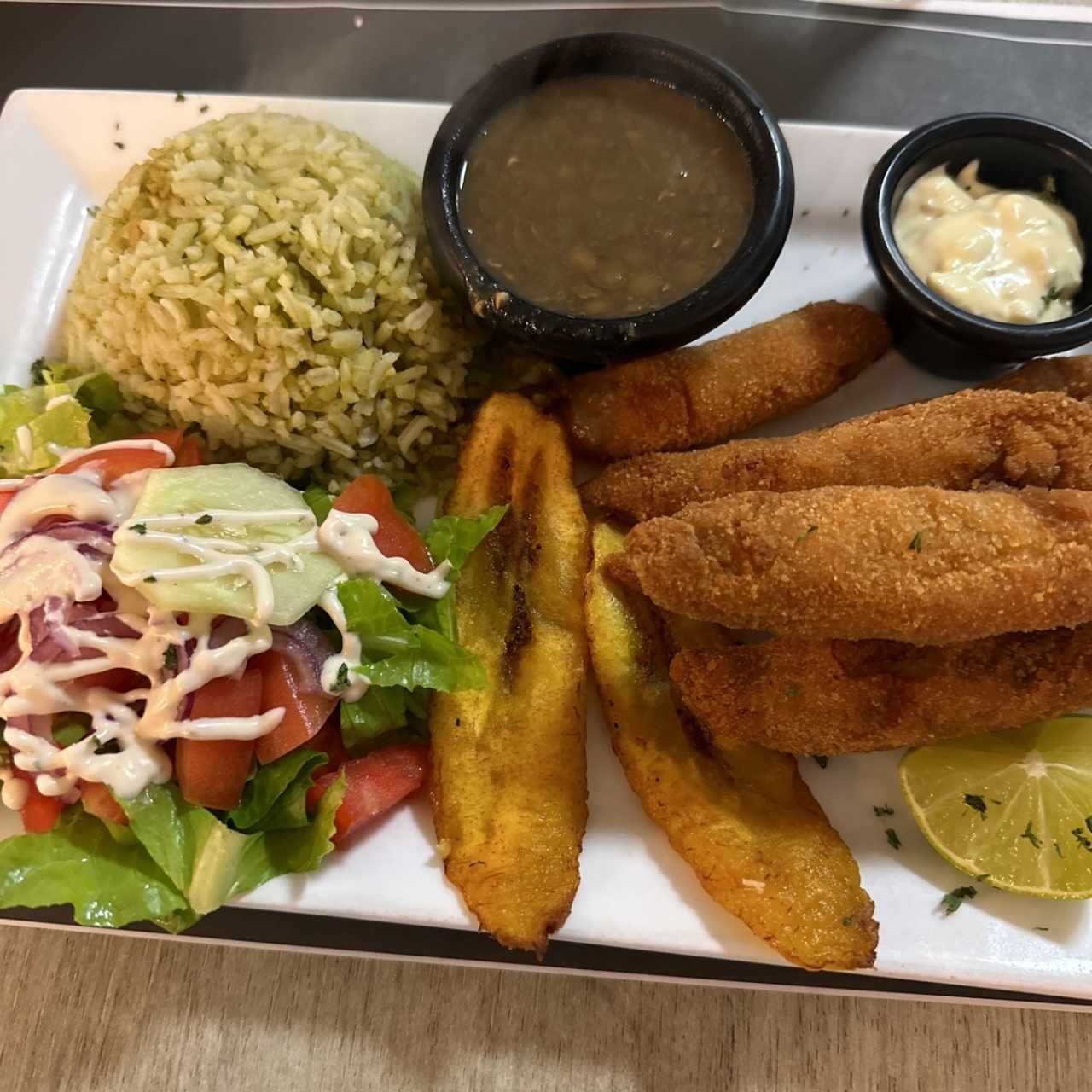 Deditos de pescado con arroz, menestra, tajada y ensalada 