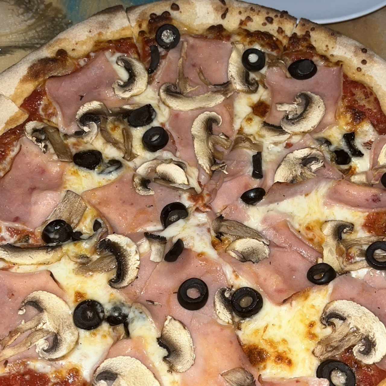 Pizza de jamón con hongos y aceitunas negras