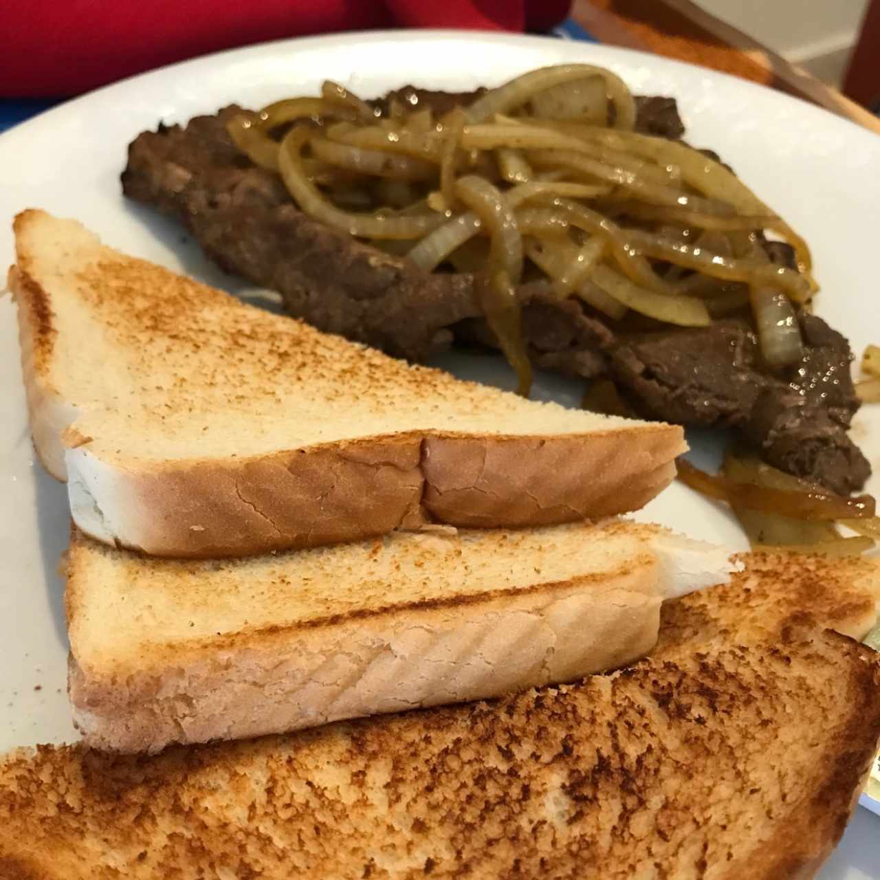 Bistec encebollado y tostadas