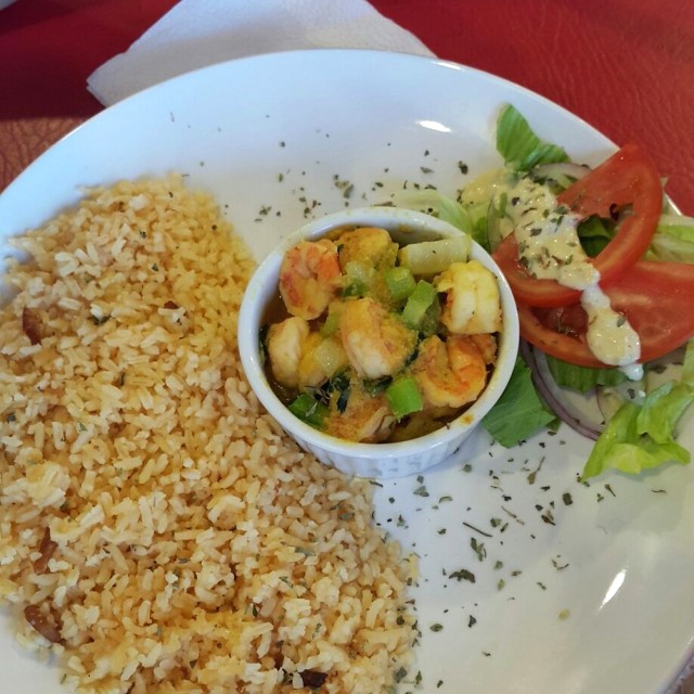 Arroz con coco y camarones secos acompañados de camarones en salsa