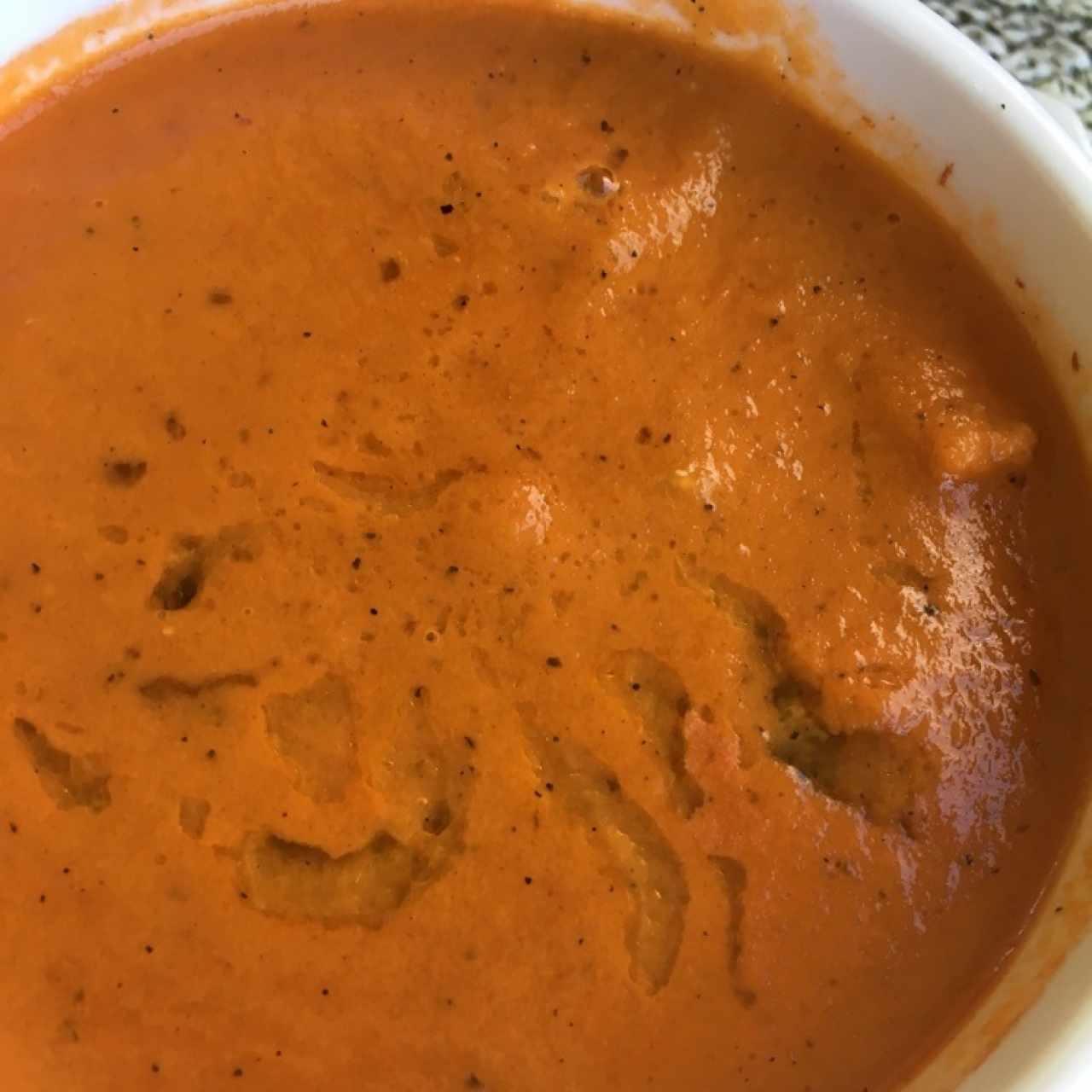 Crema de zapallo asado al horno con jengibre, aceite de achiote y conchuelas salteadas