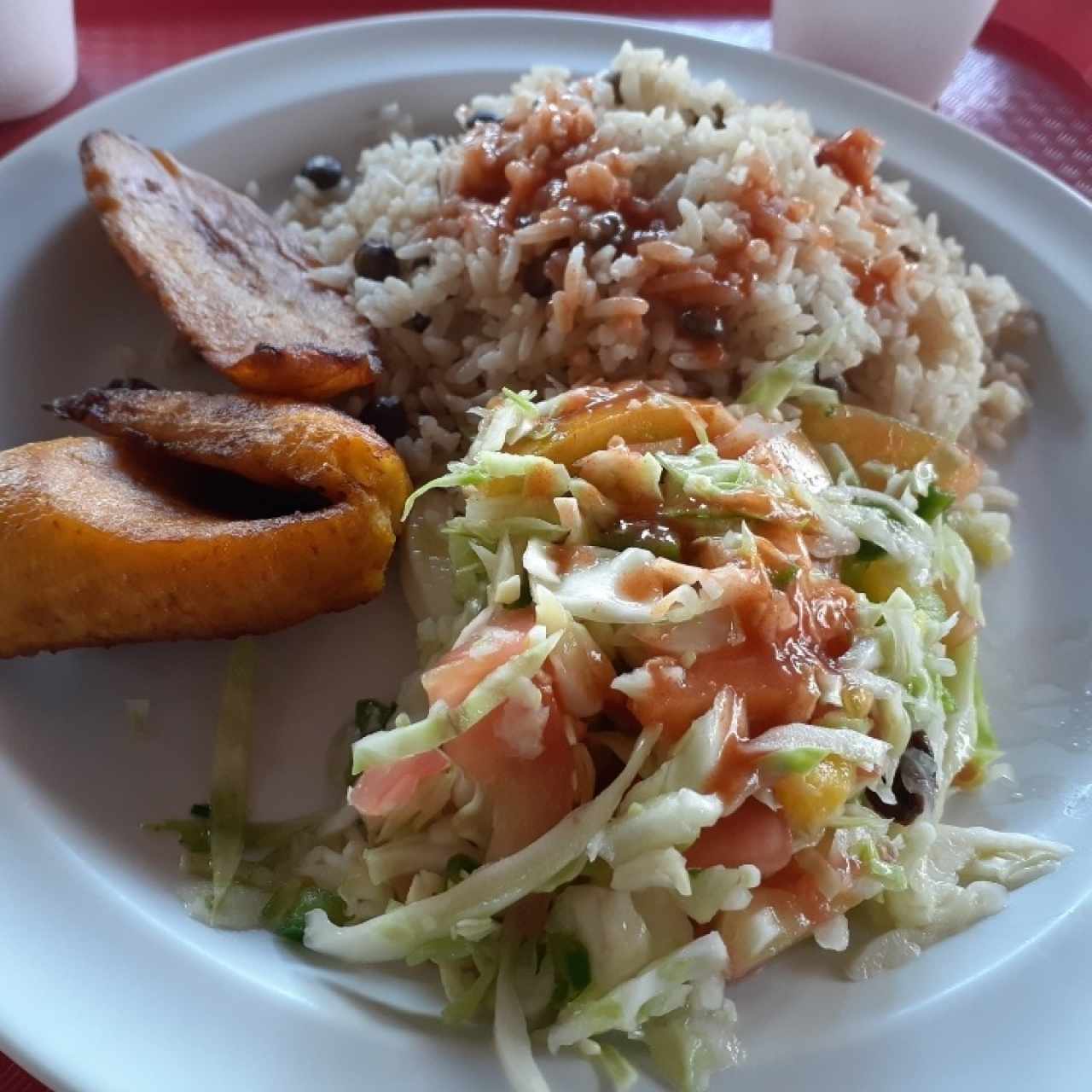 Arroz con guandú, ensalada de repollo y tajadas 