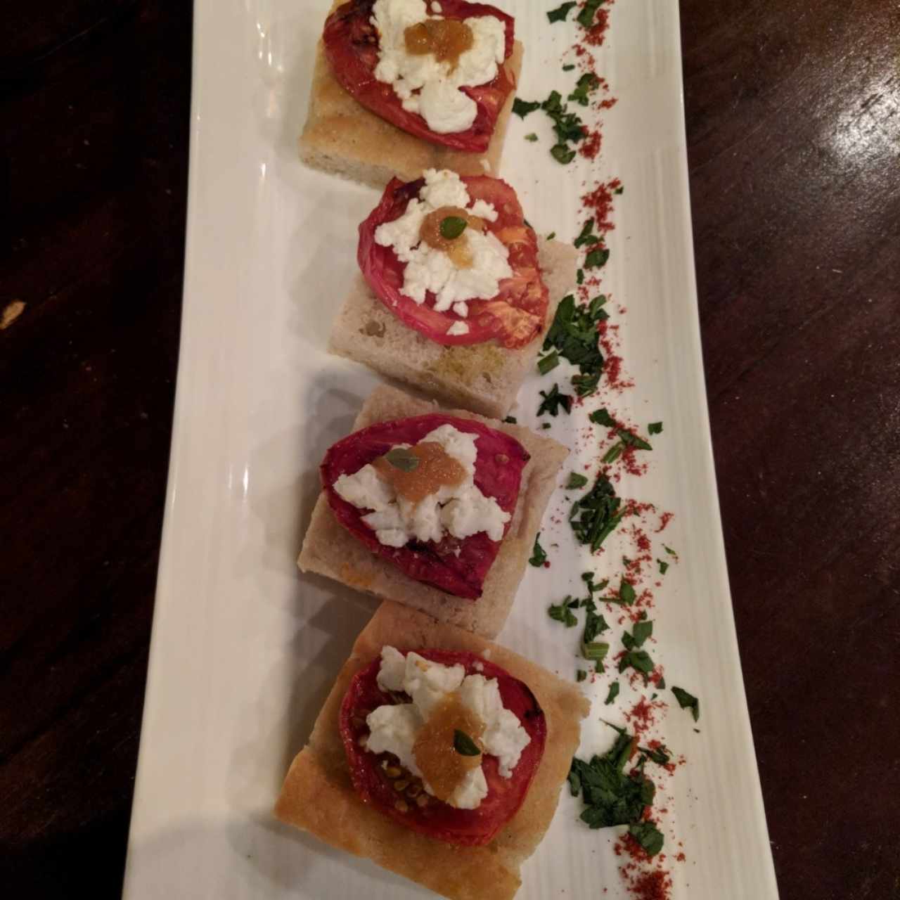 Tomate rostizado y queso de cabra sobre pan tostado