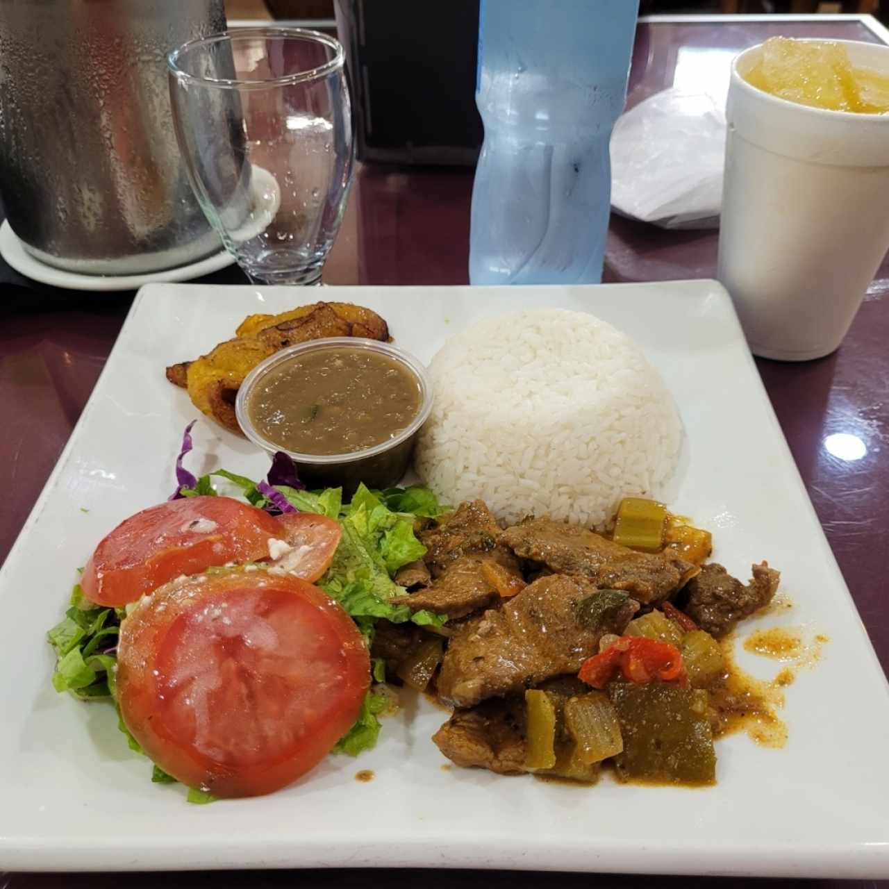 Menú de almuerzo - Bistec picado, arroz blanco, lentejas, ensalada de lechuga con tomate y tajadas. Chicha de piña😋