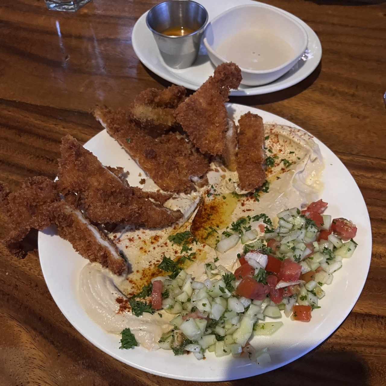 Schnitzen de pollo, hummus y ensalada israelí