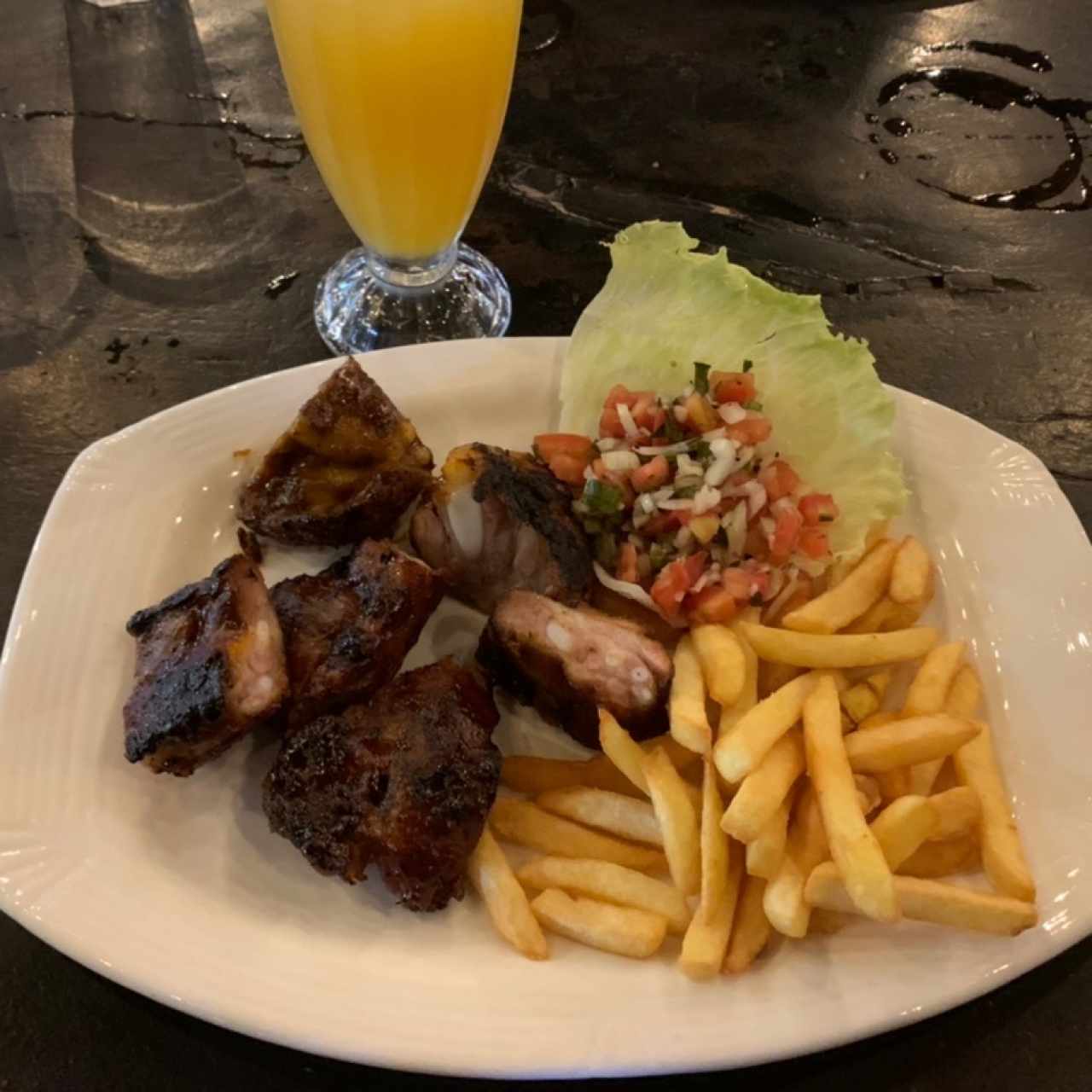 Costillas de cerdo asada con papas fritas y pico de gallo