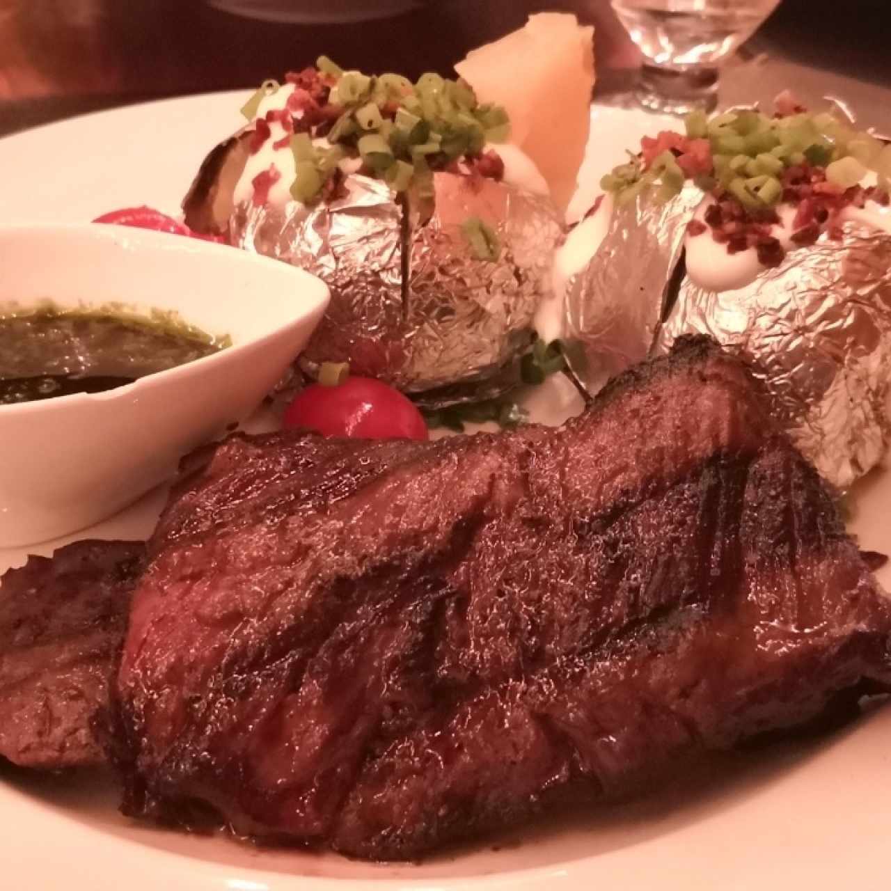 entraña, papas rellenas y salsa chimichurri