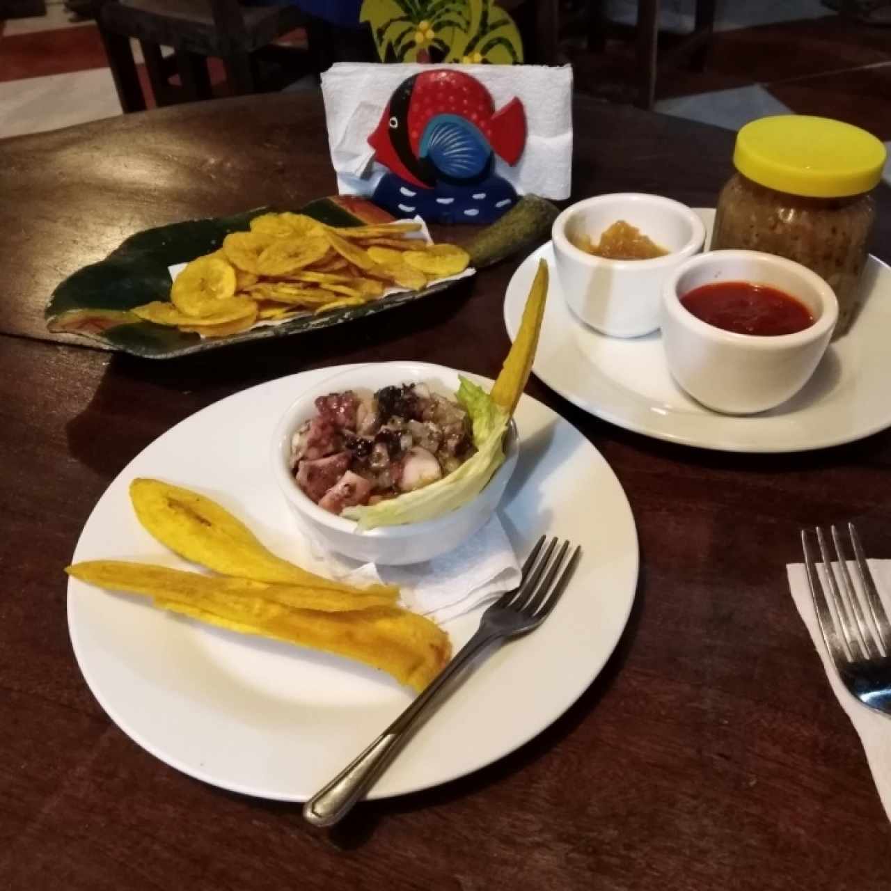 ceviche de pulpo. Platanitos, chutney de piña, salsa criolla y escabeche de ajo cortesia de la casa