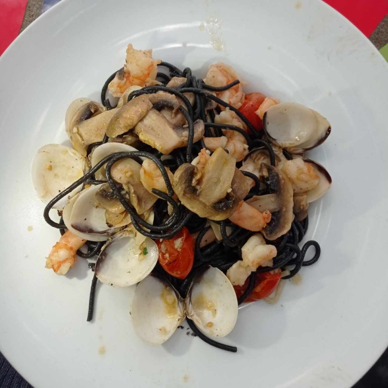 Spaghetti negro con camarones, almejas y hongos, excelente