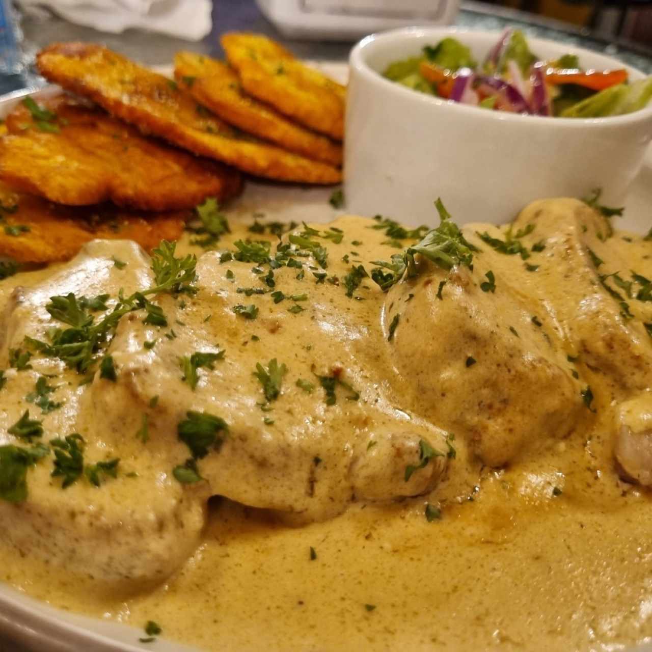 Filete de cerdo en salsa de blue cheese acompañado de patacones y ensalada 