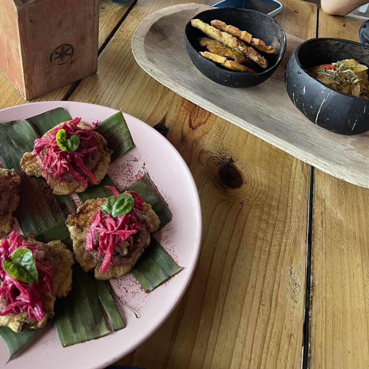 Patacones de guineo verde, mousse de frijoles y coco con rabito ahumado