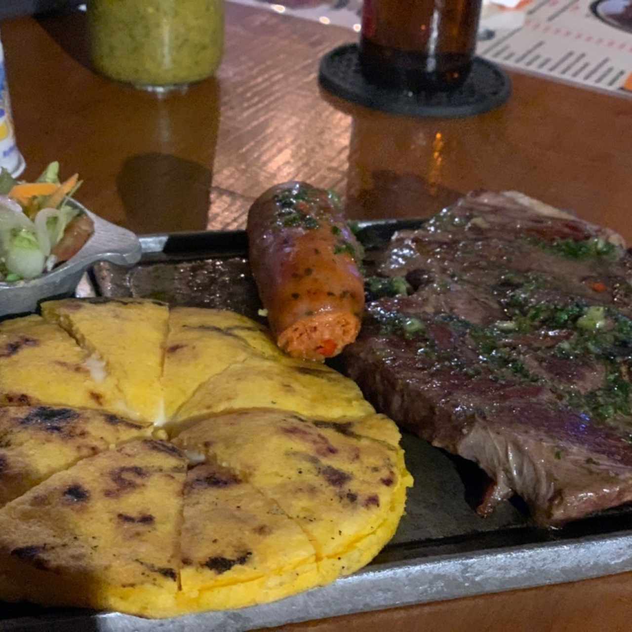 Churrasco, arepa de maíz rellena de queso y Chorozo 