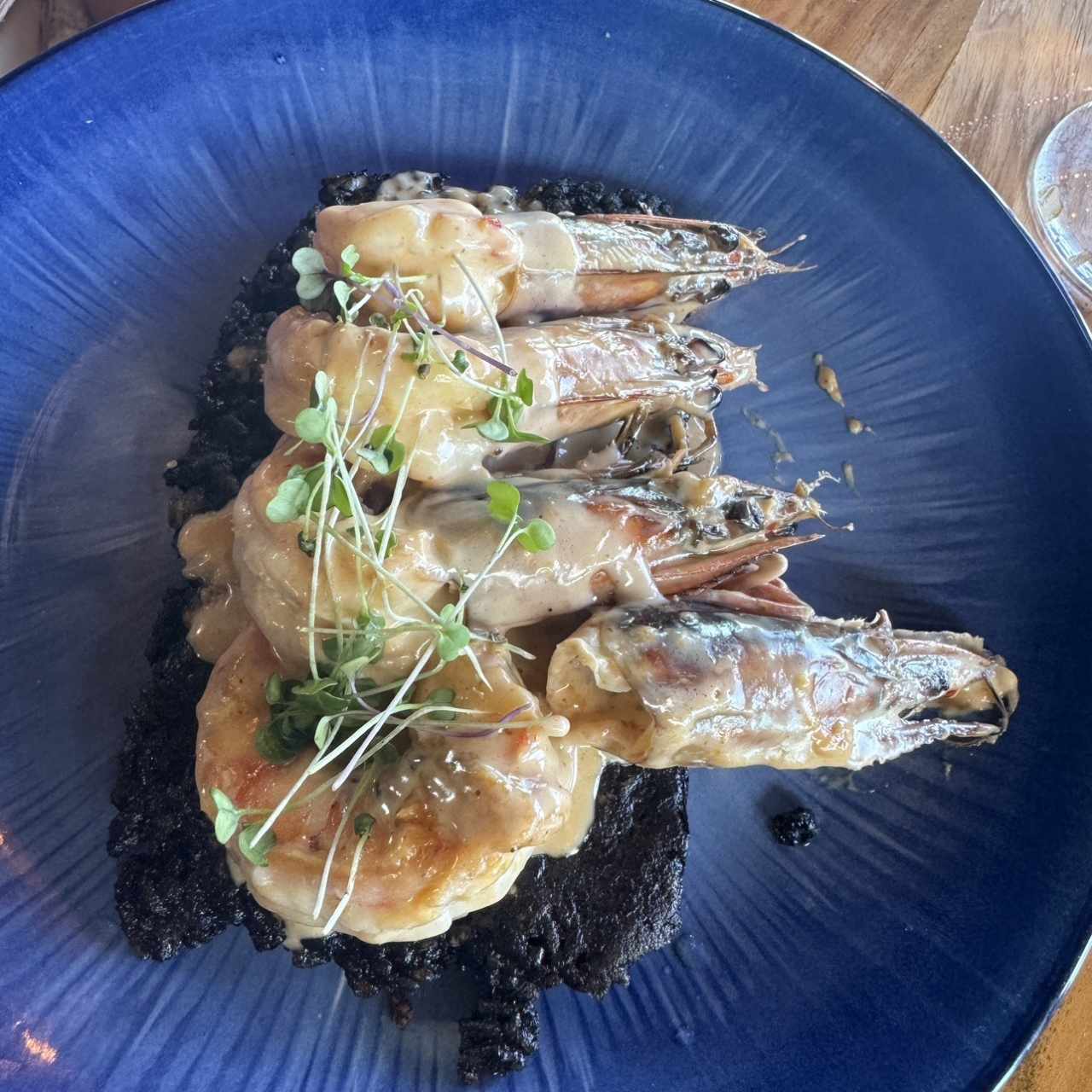 Langostinos al coco y sriracha con cocolón de arroz negro