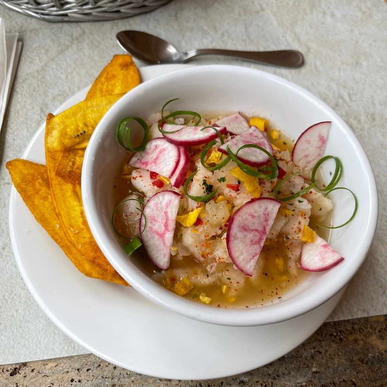 Ceviche de corvina con rábanos, emulsión de jalapeño, aceite de oliva y crocante de plátano