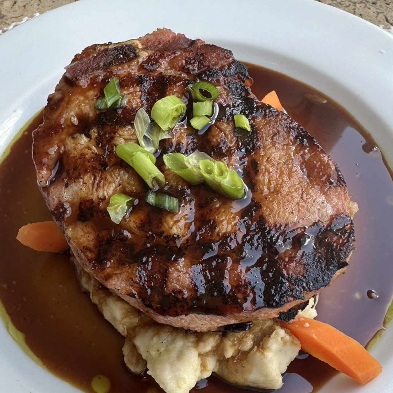 Chuleta de cerdo ahumada a la grilla con miel de caña dulce y puré de ñame