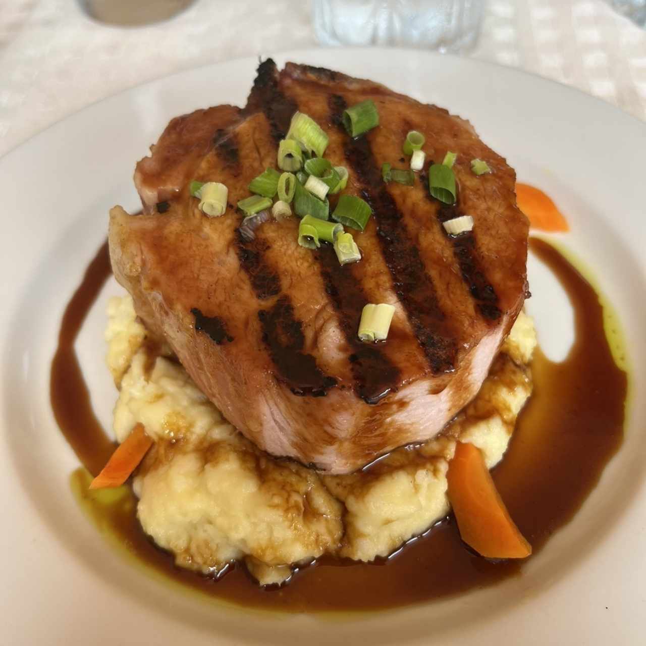 Chuleta de cerdo ahumada a la grilla con miel de caña dulce y puré de ñame