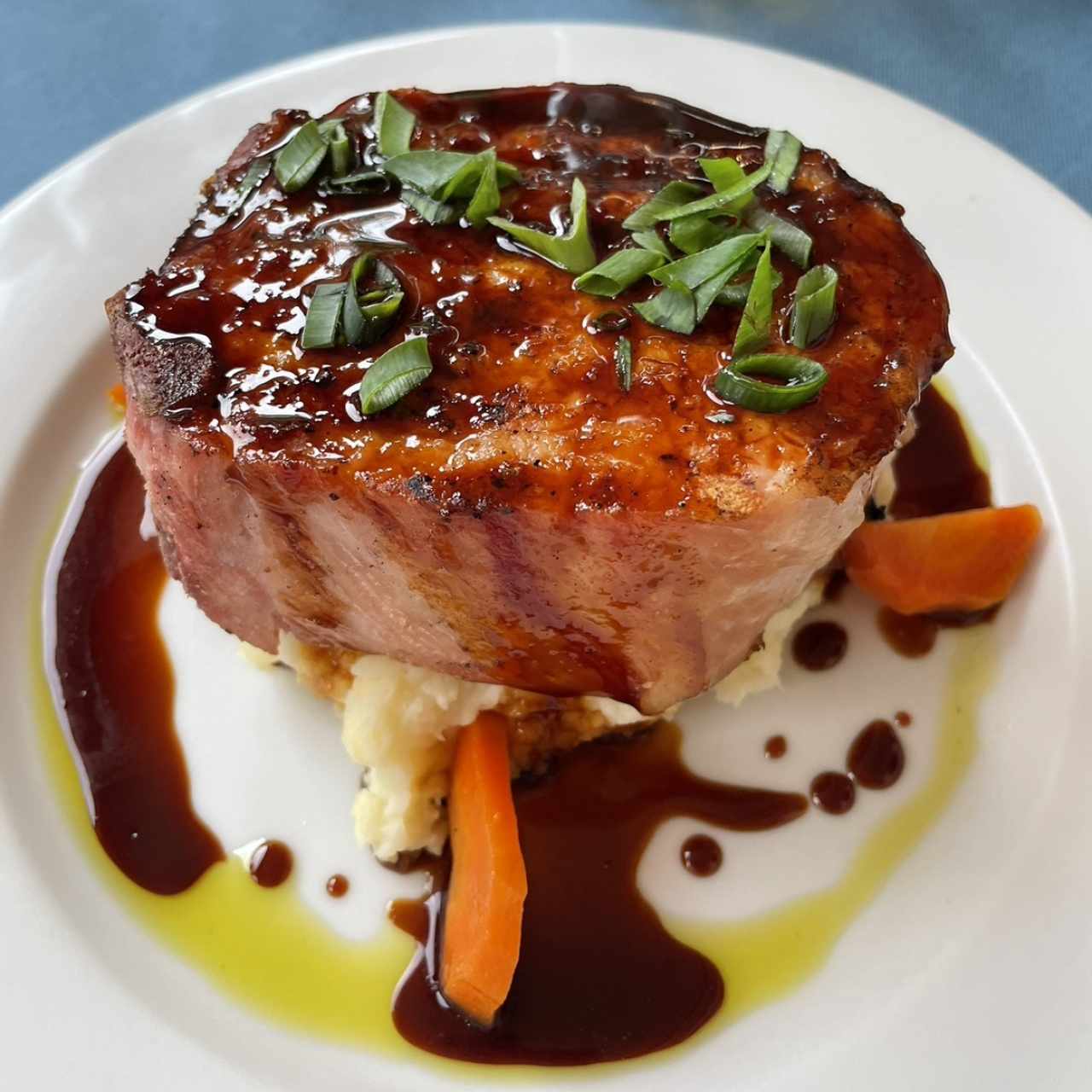 Chuleta de cerdo ahumada a la grilla con miel de caña dulce y puré de ñame