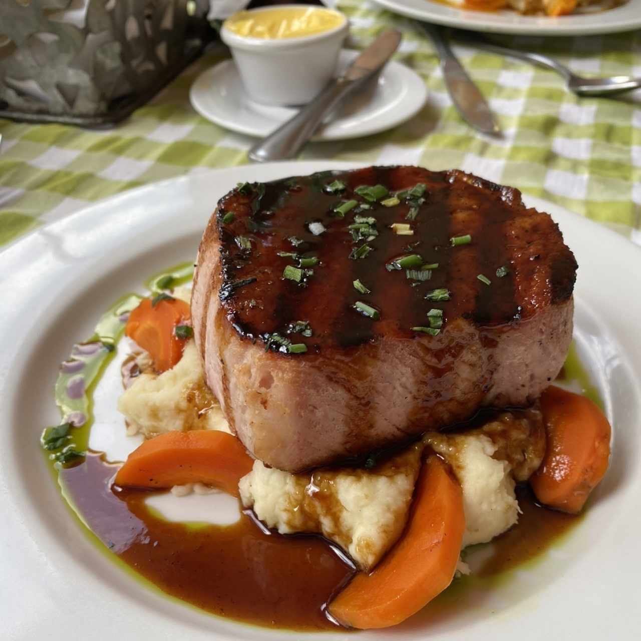 Chuleta de cerdo ahumada a la grilla con miel de caña dulce y puré de ñame