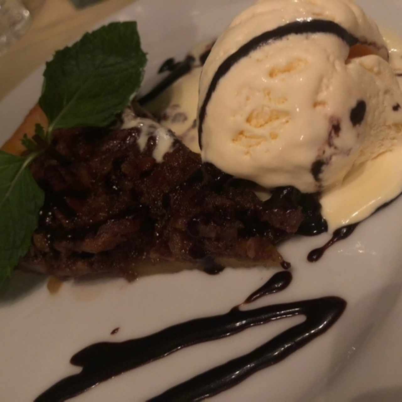 Pecan pie con helado de vainilla y salsa de chocolate