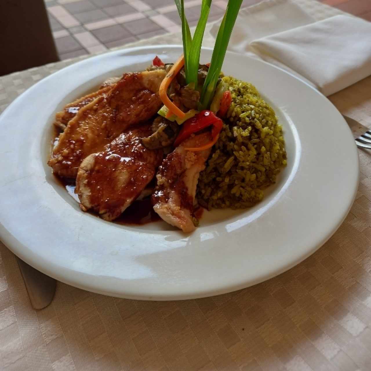 Pechuga de pollo con pepita de marañón, arroz verde y salsa de tamarindo