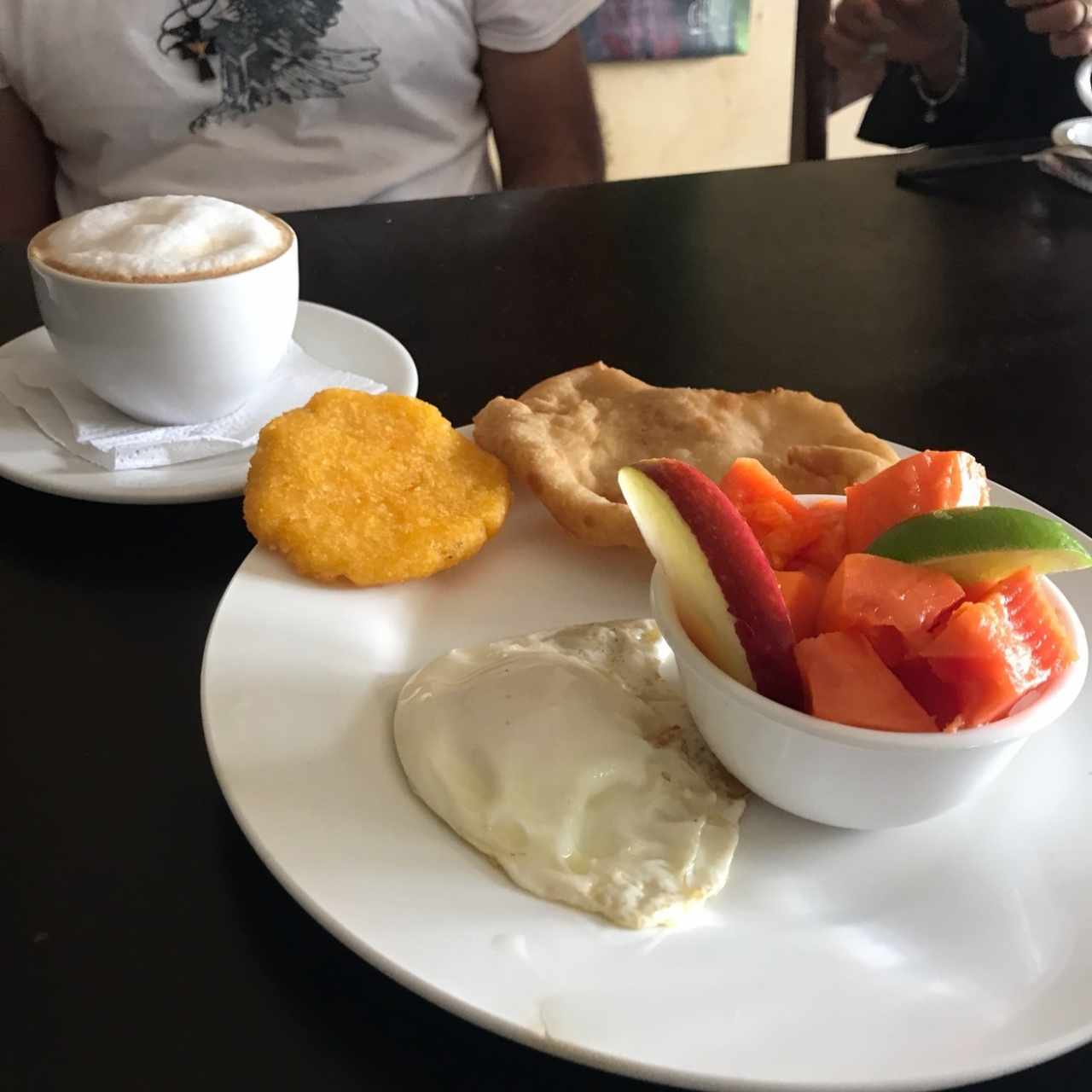 Desayuno - huevo frito con tortilla y hojaldre con un side de frutas y Capuccino