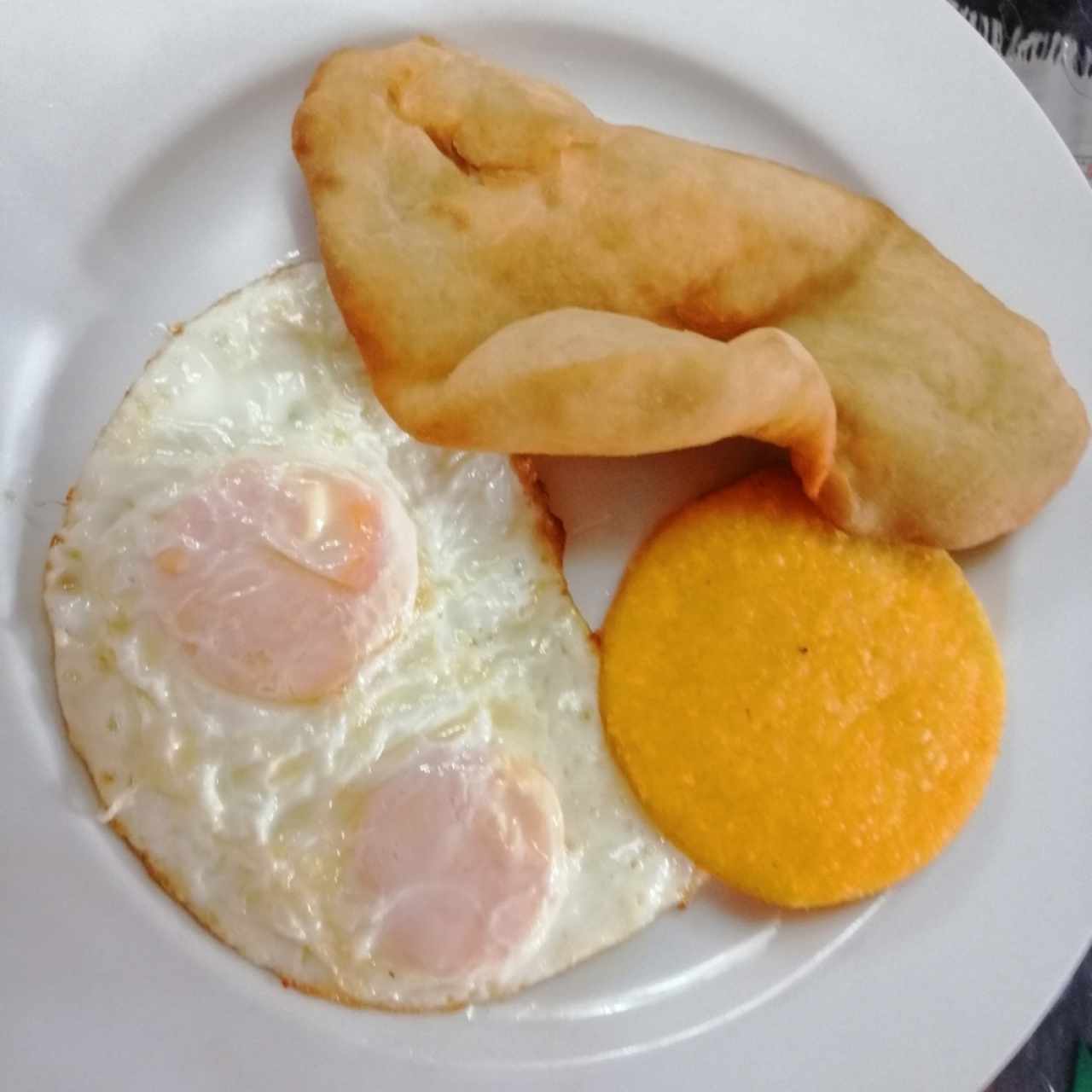 Huevos fritos medio término con tortilla hecha a mano y hojaldre