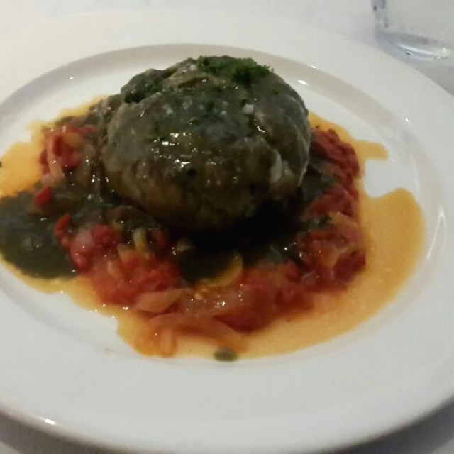 Corvina  rellena de mariscos en salsa de tinta de calamar