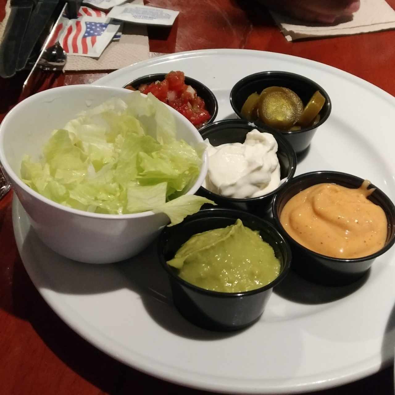 Complementos de los nachos (lechuga, jalapeños, crema agria, guacamole y salsa especial).