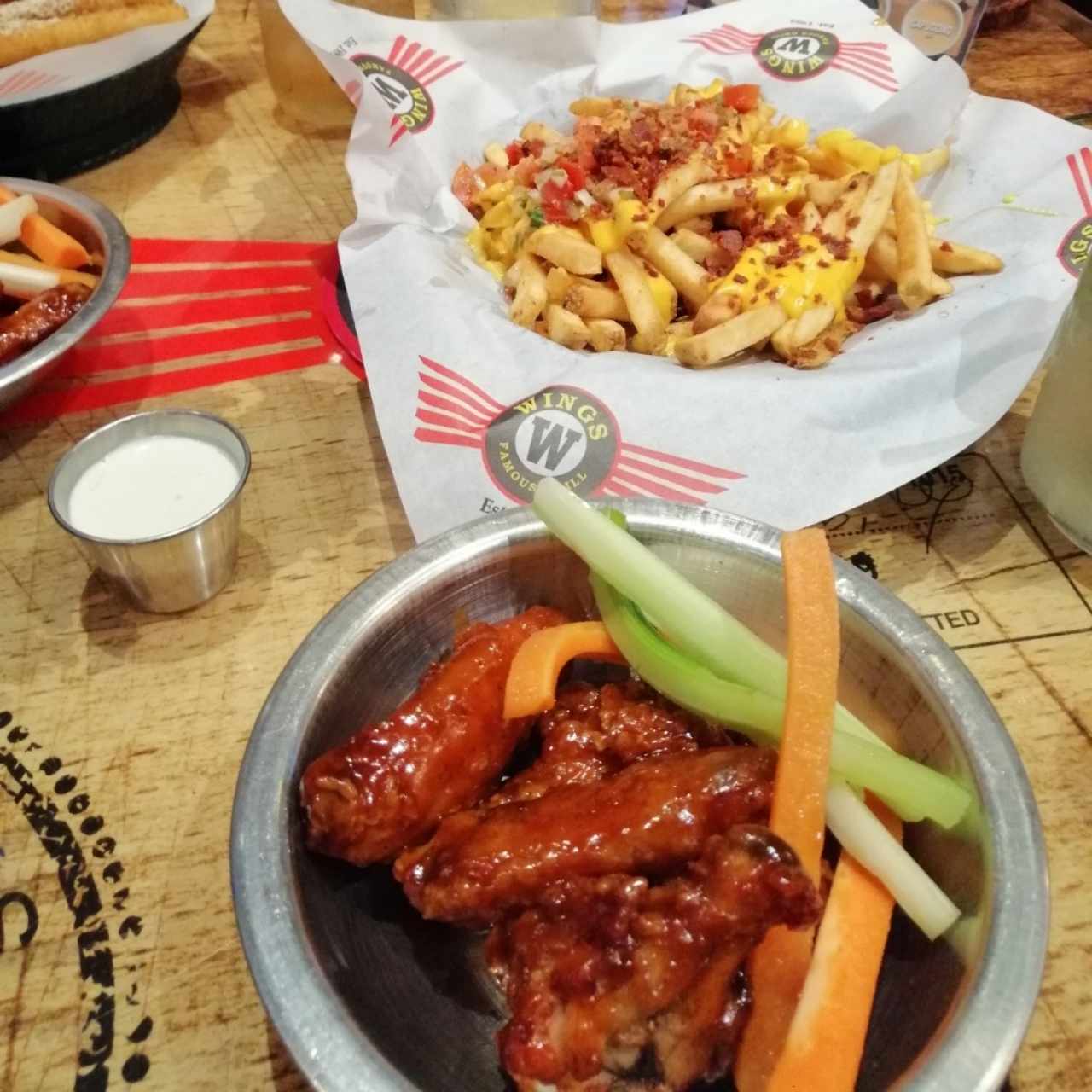 porción de wings y cheese and bacon fries