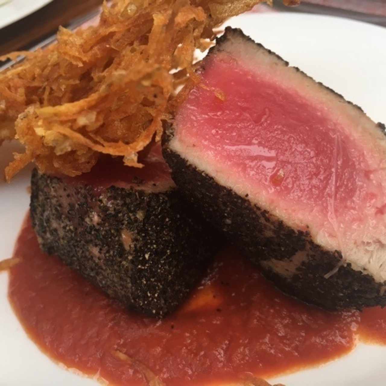 Atun a la pimienta negra sobre crema de tomate a la albahaca y crujiente de papas