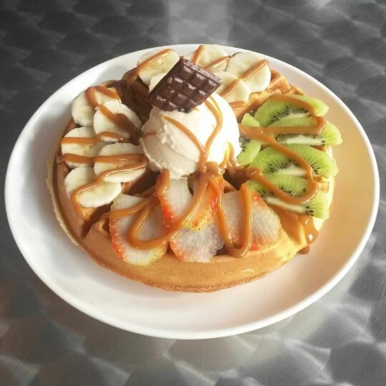 Waffle con dulce de leche, frutas y helado.