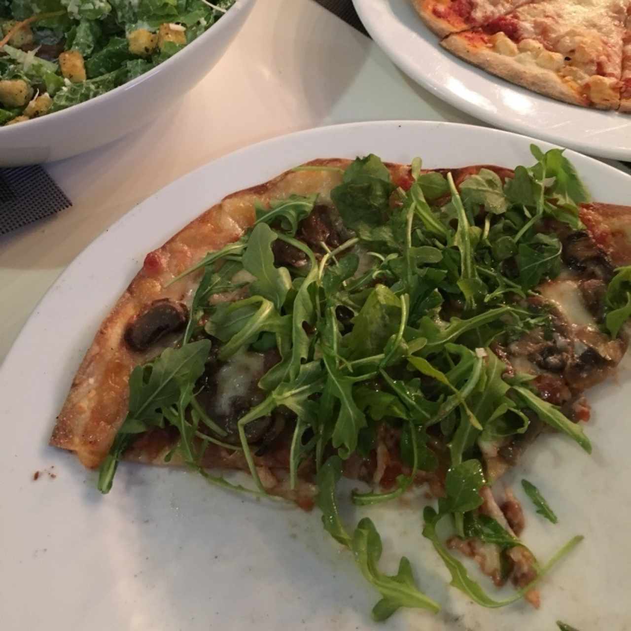 pizza con hongos, cebolla, rugula y aceite de trufa