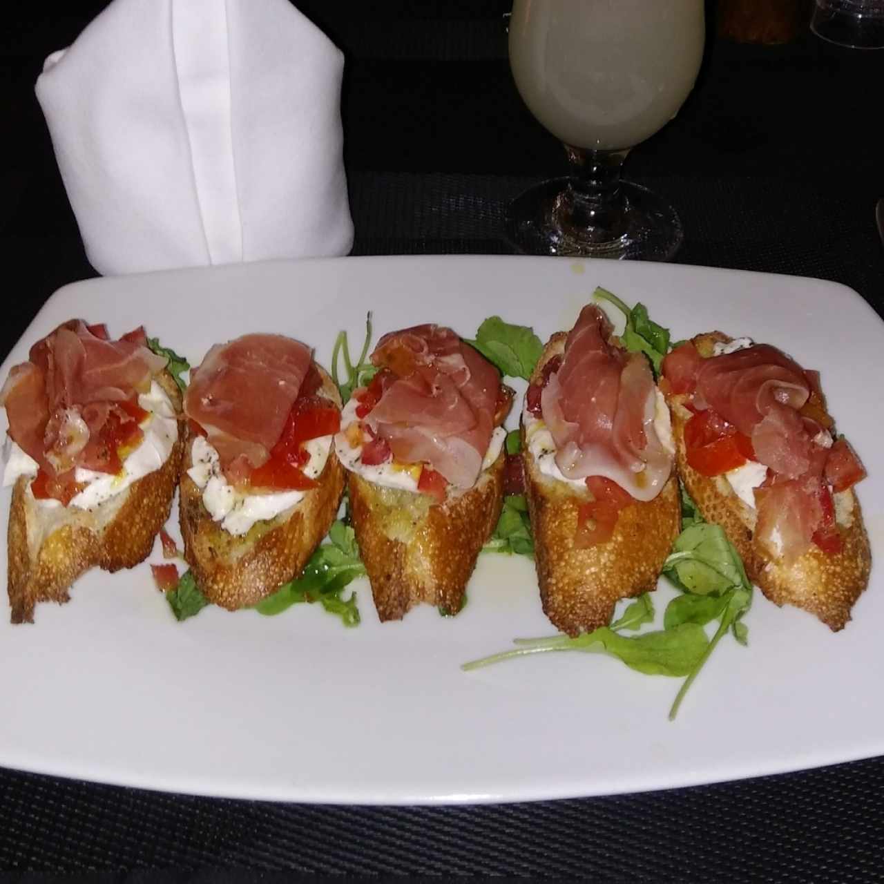 Pan, jamón serrano, tomate, queso y arúgula.