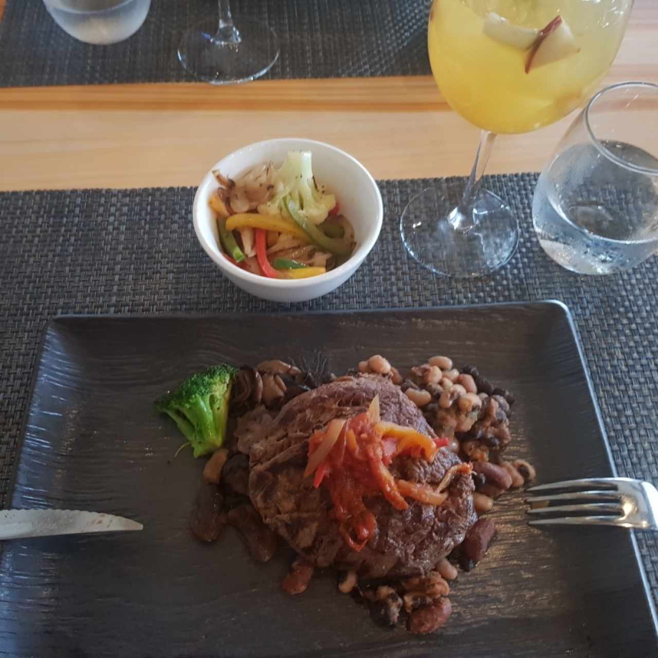 Punta de palomilla sobre una cama de hongos portobelos con frijoles chiricanos y vegetales salteados.