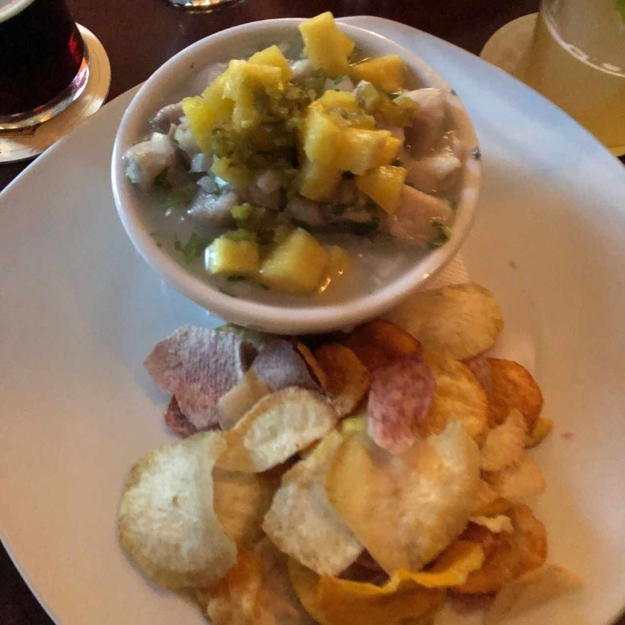 Ceviche con piña, jalapeño, y chips de la casa 