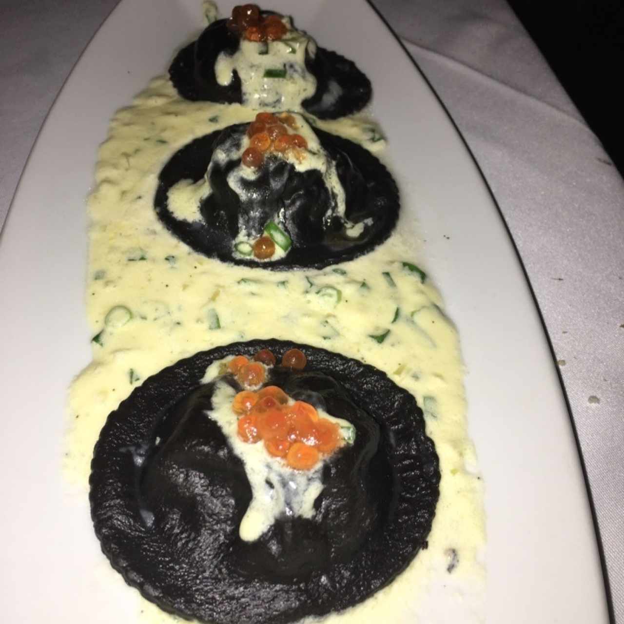 Ravioloni nero relleno de mousse de salmón