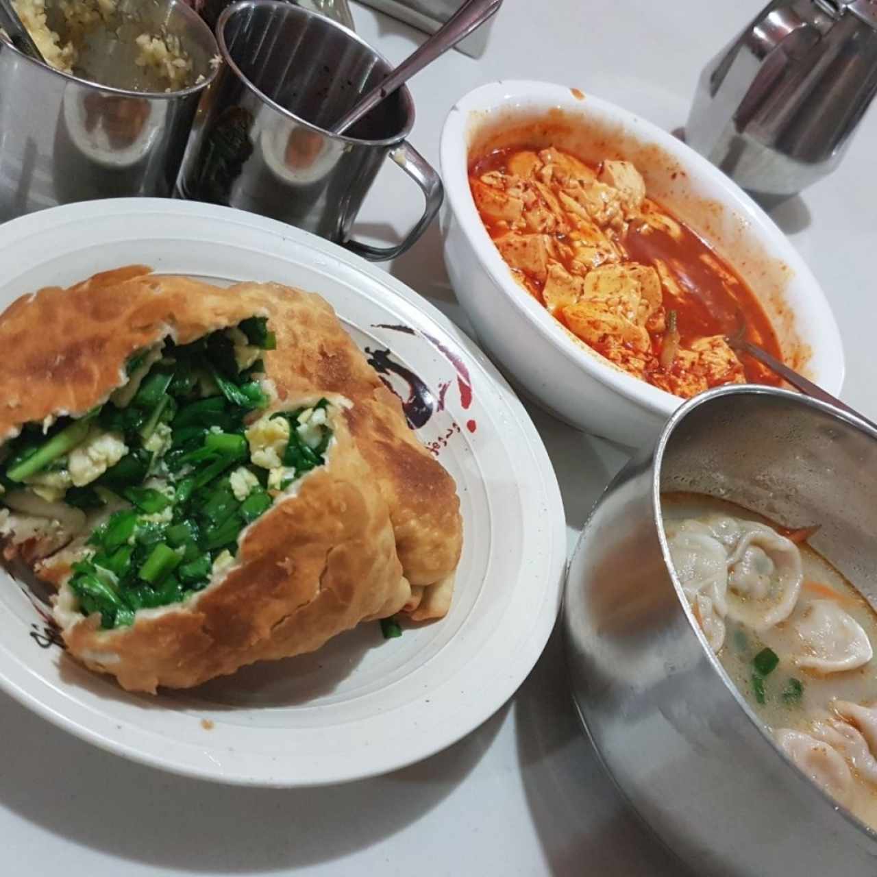 empanadas de cebollina y huevo, tofu en salsa de aceite de chile y dumplings en sopa