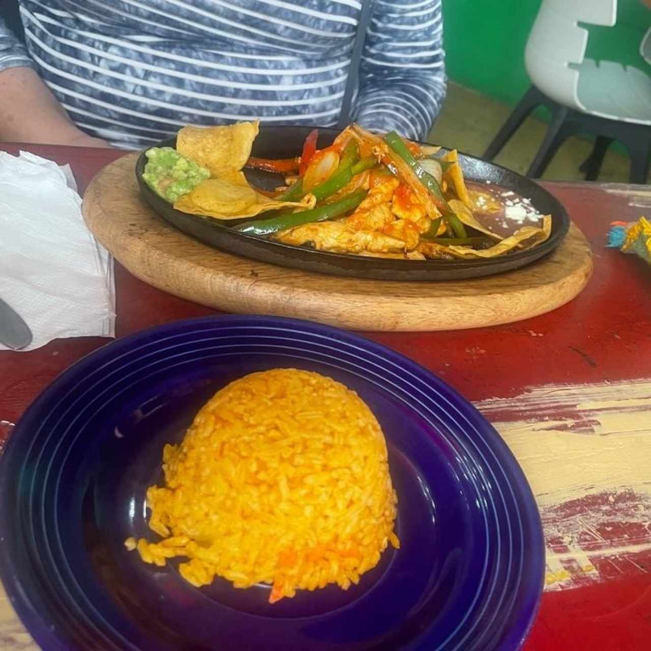 FAJITAS DE POLLO (Tiritas de Pollo, salteadas con Pimentones y Cebollas, acompañadas con Frijoles y Guacamole, Arroz y un Toque Especial de la Casa)