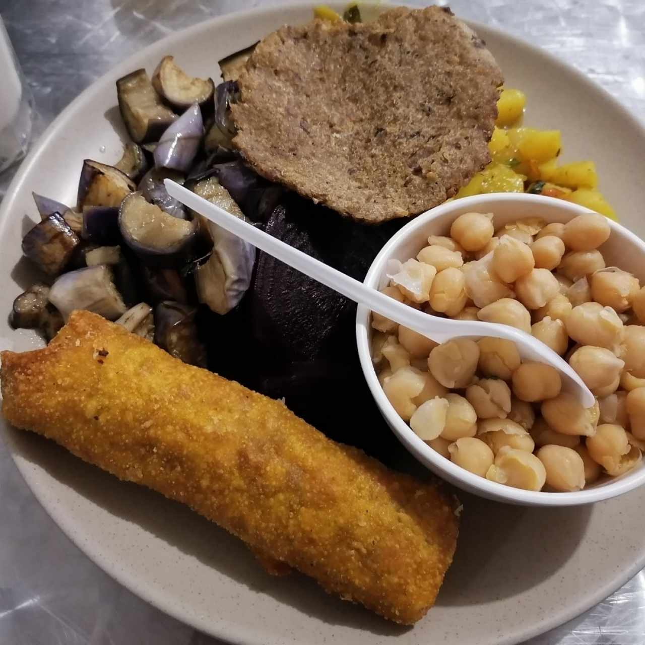 Garbanzos, ensalada de papa, berenjenas salteadas, hamburguesa de hongo, rollo de primavera. 