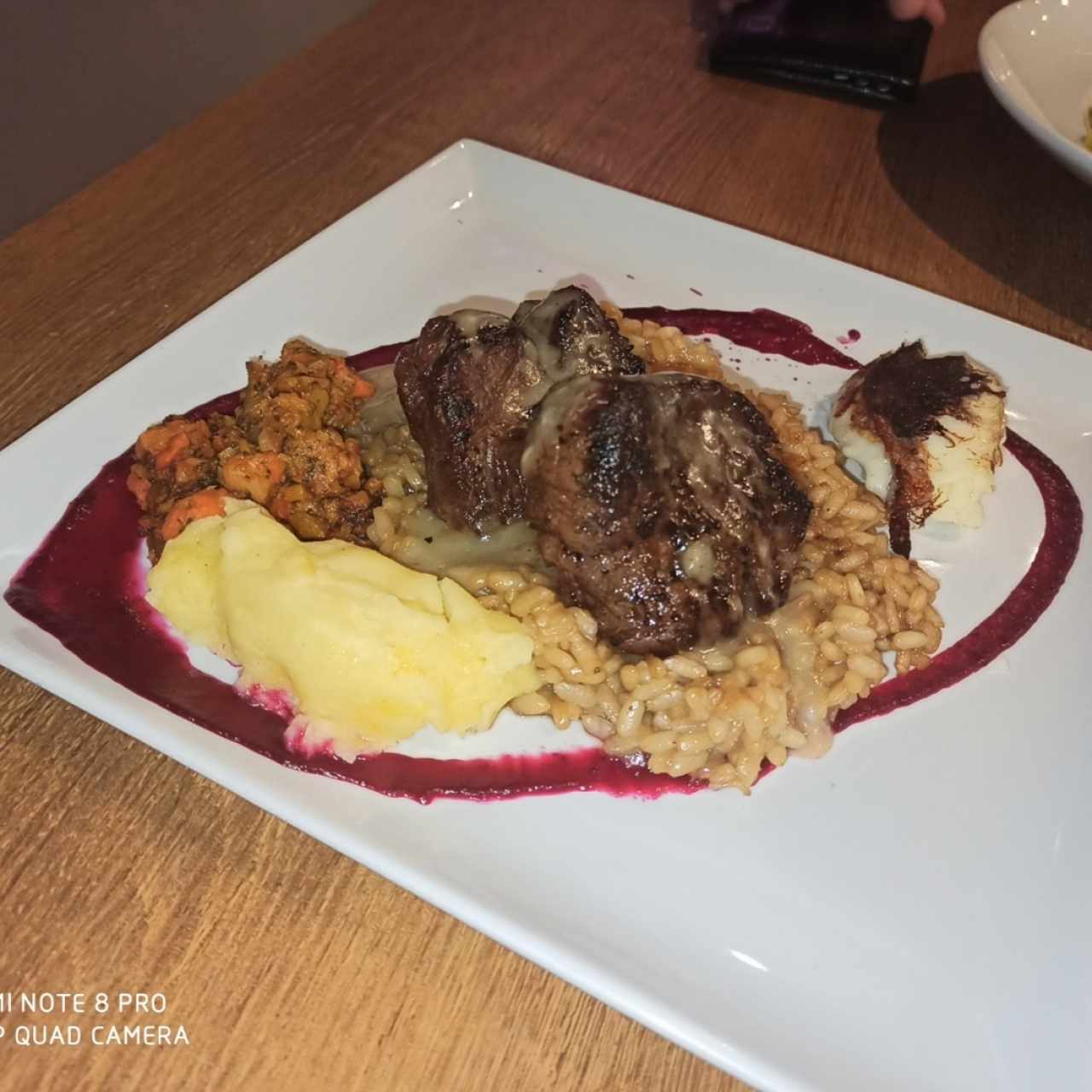 Filete de res con risotto de café, puré de papa, queso al grill y salsa de remolacha