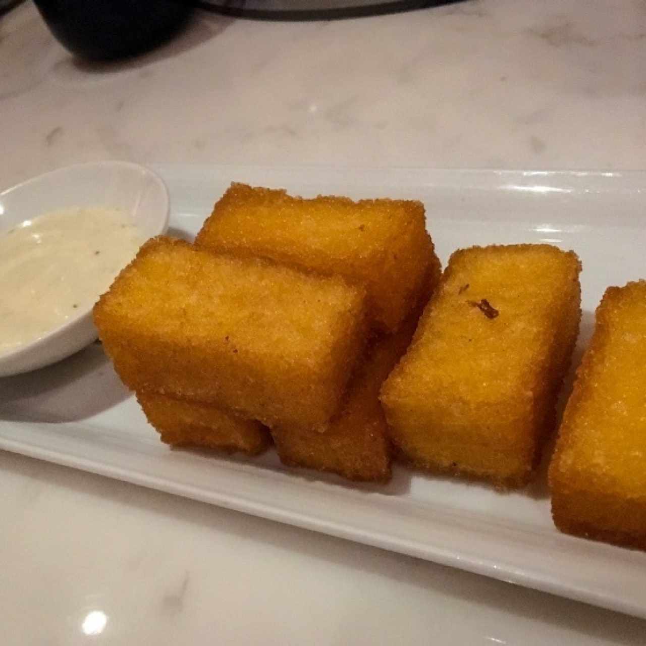 Cortesia de polenta frita con salsa de trufas