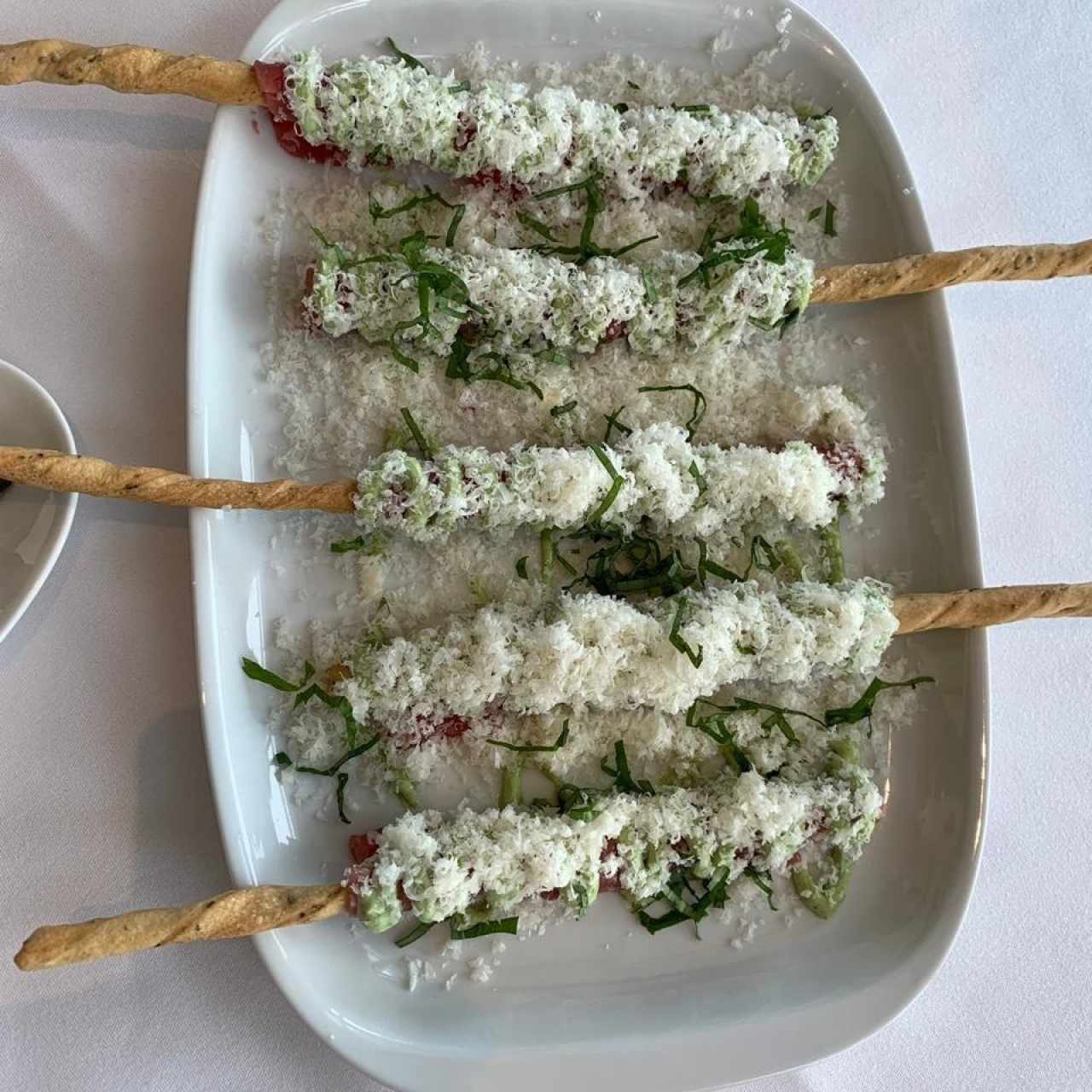 Carpaccio de filete de res sobre grissini, mayopesto y lluvia de parmensano