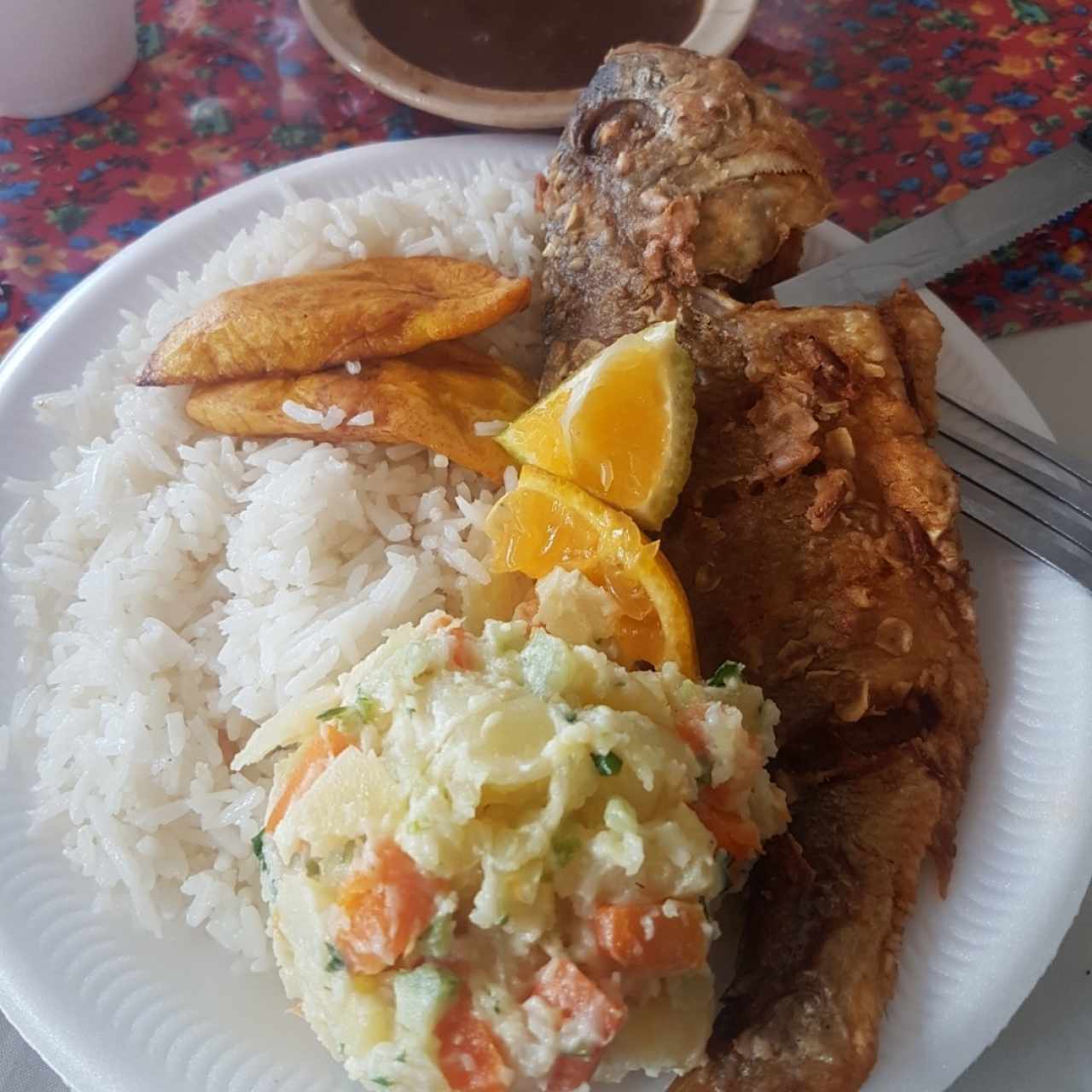 Pescado frito, arroz, porotos, ensalada de papas y tajadas