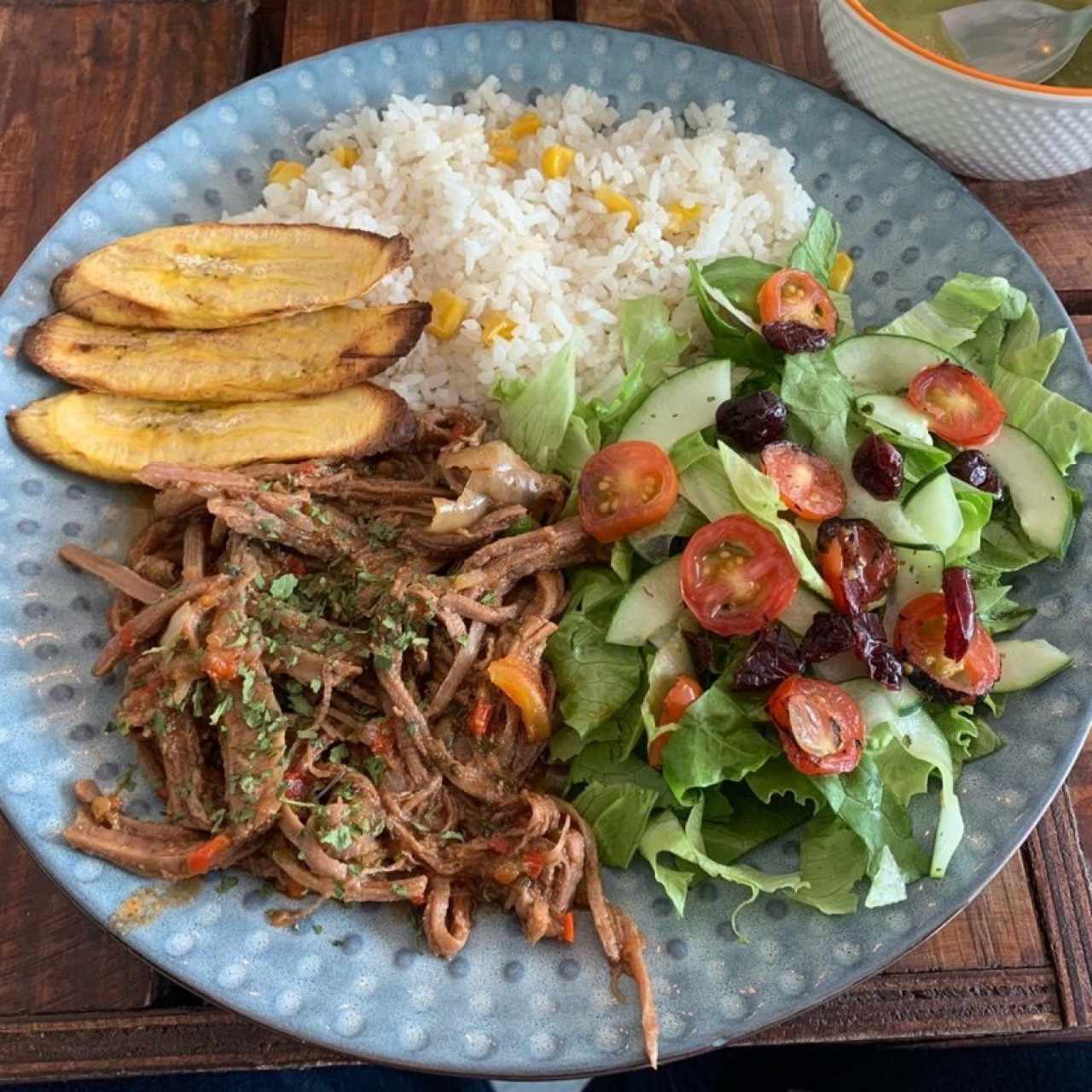 ropa vieja, ensalada, platanos maduros y arroz con maiz