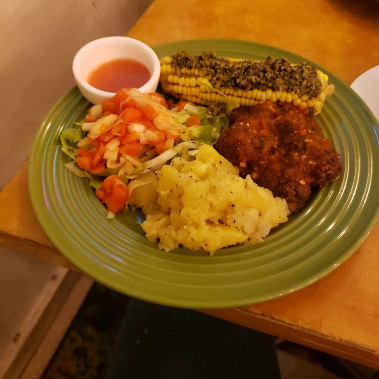 vengan Meat ball+ salsa napolitana, papas en finas hierbas, mazorca con pesto, ensalada verde.