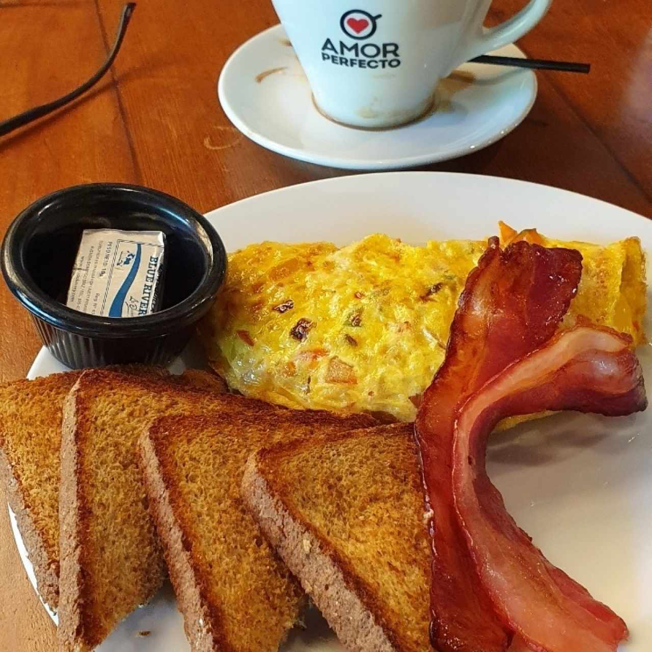 Omelette de huevo con vegetales y queso, más bacón y pan (integral) 