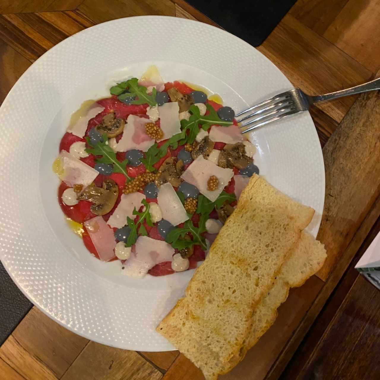 Carpaccio de Res, Creminis Asados, Parmesano D.O.P., y Mayonesa de Trufa Negra